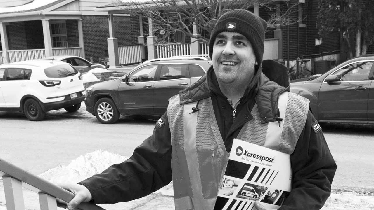 Canada Post worker delivering an envelope