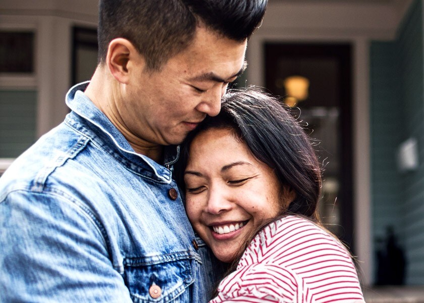 Couple hugging in front of their new home