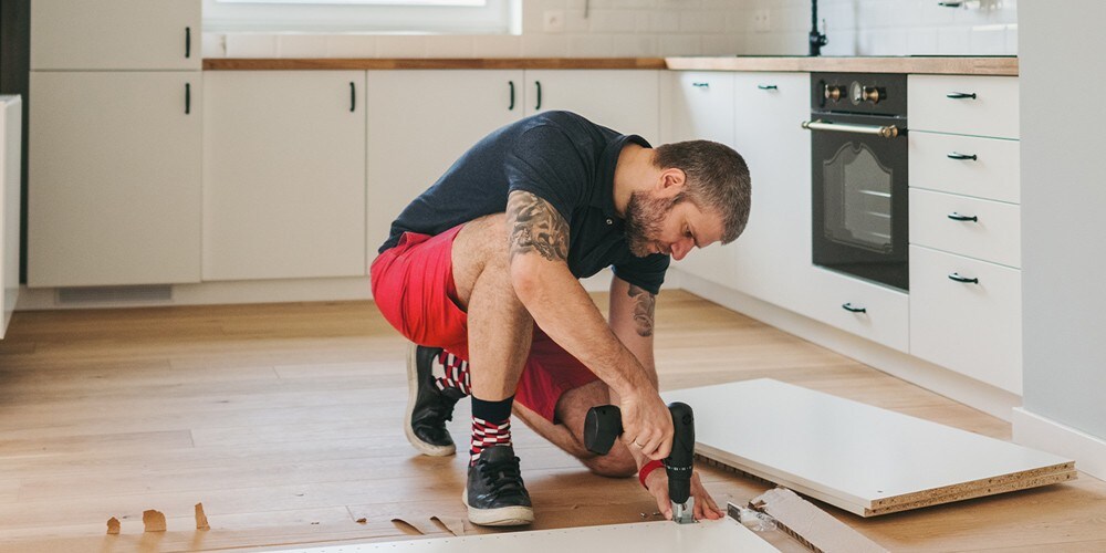 Man sitting on the edge of his bed and looking at his phone