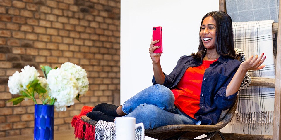 A woman looking at her phone in delight